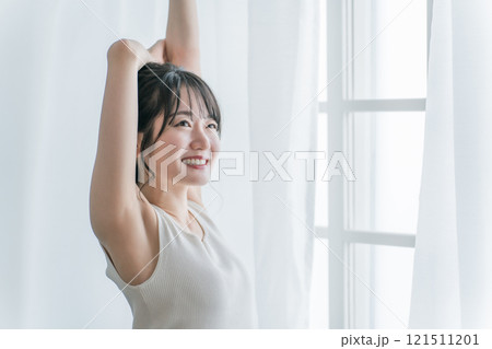 寝起き・起床時にカーテンの前で朝日を浴びる女性(笑顔) 寝起き・起床時にカーテンの前で朝日を浴びる女性(笑顔) 121511201