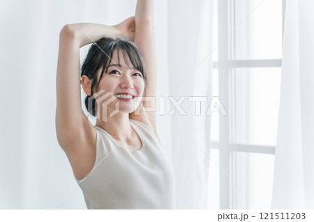 寝起き・起床時にカーテンの前で朝日を浴びる女性(脱毛・脇) 寝起き・起床時にカーテンの前で朝日を浴びる女性(脱毛・脇) 121511203