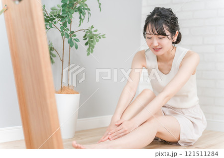 家でフットケア・マッサージして浮腫みの悩みが解消された笑顔の日本人女性 121511284