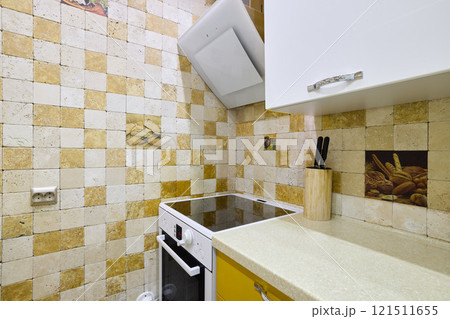 A Cozy Kitchen that features Modern Appliances along with Beautiful Decorative Tiles 121511655