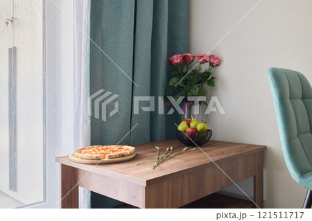 Experience a Cozy Dining Corner adorned with delicious Pizza and Fresh Flowers for ambiance Experience a Cozy Dining Corner adorned with delicious Pizza and Fresh Flowers for ambiance 121511717