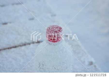 A Frosted Frozen Water Bottle with Ice Crystals on a Cold, Frosty Surface Environment A Frosted Frozen Water Bottle with Ice Crystals on a Cold, Frosty Surface Environment 121511728