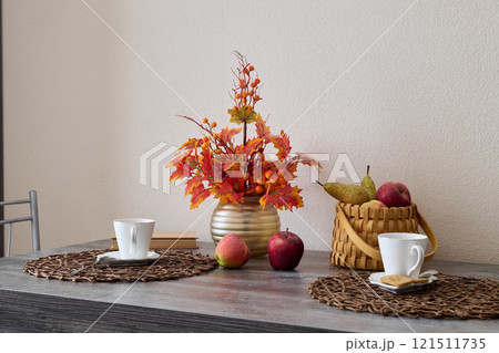 A Cozy Autumn Table Setting Featuring Beautiful Fruit and Decorative Flowers for Enjoyment 121511735