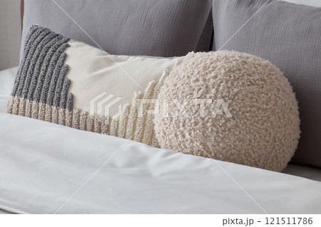 Cozy and Textured Pillows Beautifully Arranged on a Stylish Modern Bed for Comfort and Aesthetics Cozy and Textured Pillows Beautifully Arranged on a Stylish Modern Bed for Comfort and Aesthetics 121511786