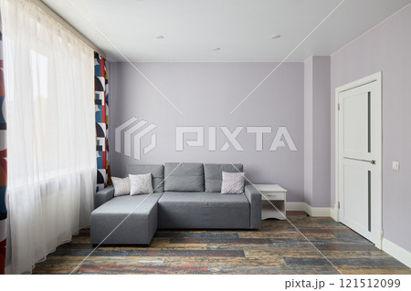 Discover a modern living room with a stylish gray sofa and bright, large windows 121512099