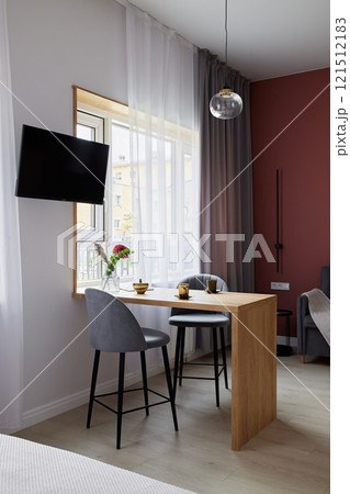 Cozy and modern apartment interior featuring a dining area along with a television set 121512183