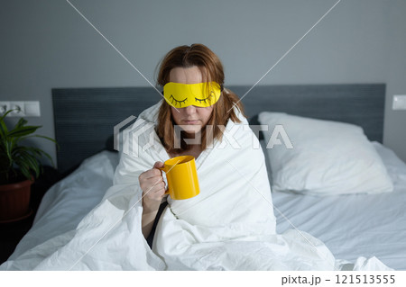 Enjoying a Relaxed Morning Experience with Coffee, a Sleep Mask, and a Cozy Atmosphere 121513555