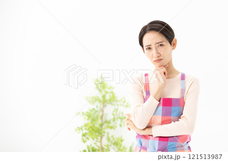 エプロン姿で悩んでいる女性のイメージ　(写真素材) 121513987