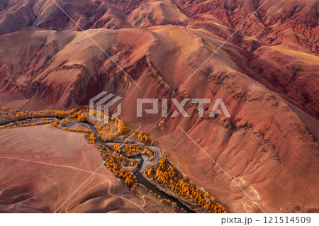 Aerial view of vibrant red mountains and winding river in autumn landscape 121514509