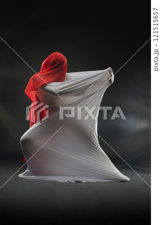 Creative fabric art performance with flowing materials in a studio setting 121515657