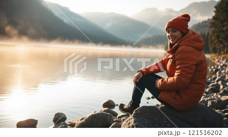 person in an orange jacket seated on a rock person in an orange jacket seated on a rock 121516202