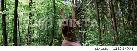 Toddler girl standing in a forest with her arms raised in victorious gesture Toddler girl standing in a forest with her arms raised in victorious gesture 121517072