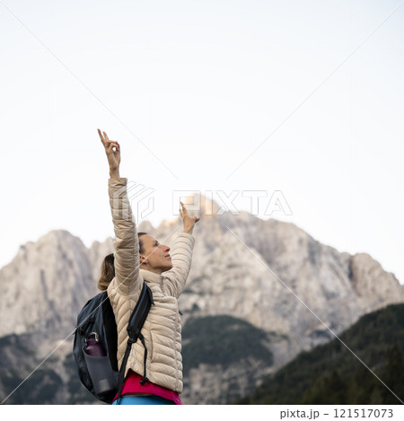 Triumphant in female hiker in nature's embrace 121517073