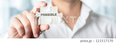 Businessman holding puzzle piece with Possible text Businessman holding puzzle piece with Possible text 121517170