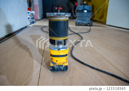Close Up of Yellow and Black Router on Wooden Floor in Workshop 121518565
