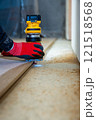 Person Using Yellow Router on Wood with Red Gloves Indoors 121518568