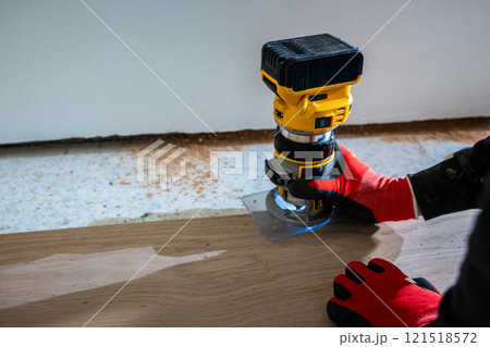 Carpenter Using Yellow and Black Router on Wooden Surface 121518572