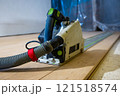 Close Up of Track Saw with Dust Hose on Wooden Floor 121518574