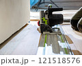 Close Up of Track Saw Cutting Wood Flooring on Guide Rail 121518576