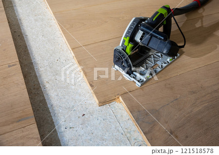 Close Up of Track Saw Cutting Wooden Planks on Indoor Floor Close Up of Track Saw Cutting Wooden Planks on Indoor Floor 121518578