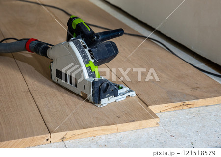 Circular Saw on Wooden Floorboards in Construction Setting Circular Saw on Wooden Floorboards in Construction Setting 121518579