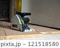 Track Saw with Dust Extraction Hose on Wooden Planks Indoors 121518580