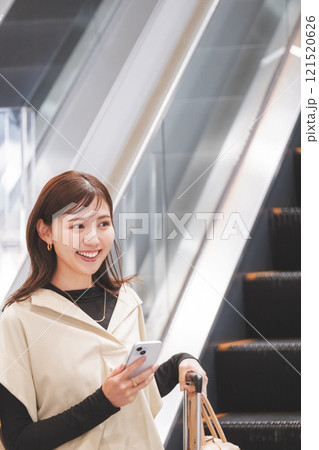 空港に到着しエスカレーターからか降りてくる女性 121520626