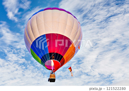 Colorful hot air balloon flying over blue sky with white clouds 121522280