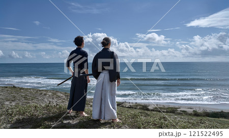 刀を携えて海を見つめる2人の男性の後ろ姿 刀を携えて海を見つめる2人の男性の後ろ姿 121522495