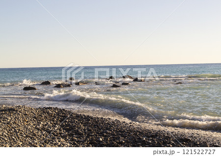 Teal sea wave crashing near a rocky shore, sea storm background 121522727