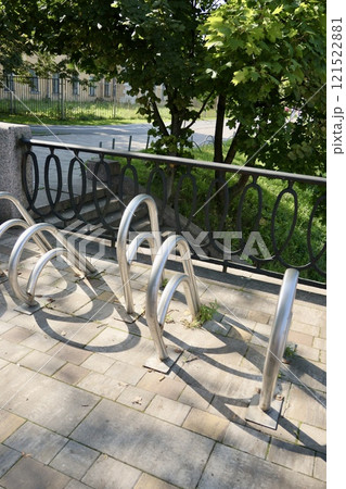metal bicycle parking in business part of city or in park, gray colorful white-standing counter 121522881