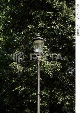 Vintage glass street lamp, lantern on high pole in park. Ideal for historical architecture Vintage glass street lamp, lantern on high pole in park. Ideal for historical architecture 121522886