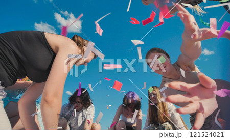 Group of high school students throwing colorful confetti in the air, celebrating the end of school year under a bright summer sky Group of high school students throwing colorful confetti in the air, celebrating the end of school year under a bright summer sky 121524021