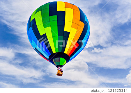 Colorful hot air balloon flying over blue sky with white clouds Colorful hot air balloon flying over blue sky with white clouds 121525314