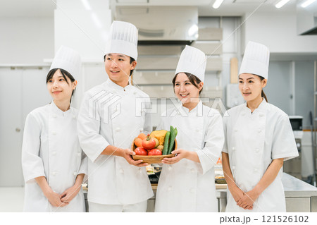 野菜を持つコックコート姿のシェフ・コック・調理師の男女 121526102