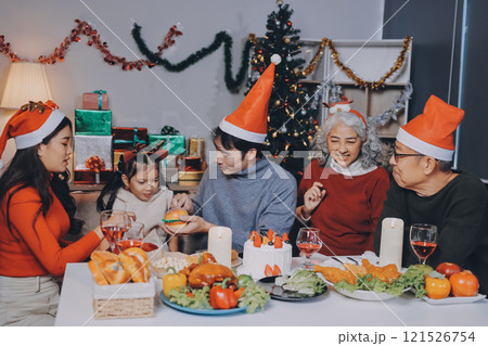 Happy multigeneration family enjoying in opening gifts on Christmas eve at home. 121526754