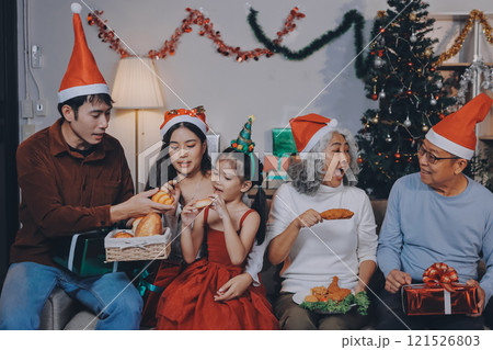 Portrait of Asian family exchanging presents during christmas at home. Attractive happy people holding gift box, celebrate holiday thanksgiving, xmas eve tradition in living room in house together. Portrait of Asian family exchanging presents during christmas at home. Attractive happy people holding gift box, celebrate holiday thanksgiving, xmas eve tradition in living room in house together. 121526803