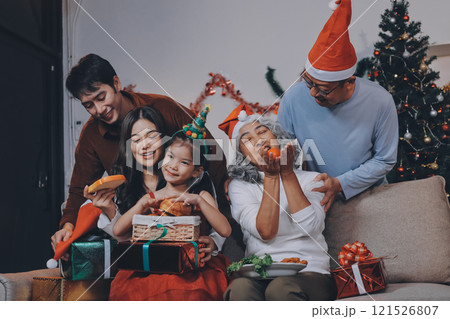 Portrait of Asian family exchanging presents during christmas at home. Attractive happy people holding gift box, celebrate holiday thanksgiving, xmas eve tradition in living room in house together. Portrait of Asian family exchanging presents during christmas at home. Attractive happy people holding gift box, celebrate holiday thanksgiving, xmas eve tradition in living room in house together. 121526807
