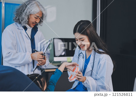 A team of doctors and nurses are working to treat a female patient in the patient's room. A team of doctors and nurses are working to treat a female patient in the patient's room. 121526811