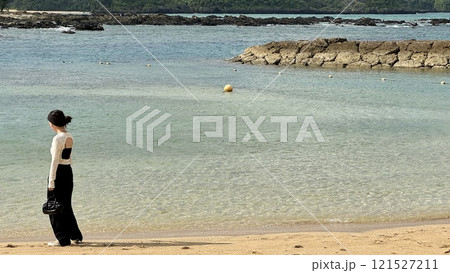沖縄瀬良垣島のビーチで朝の散歩をする女性 121527211