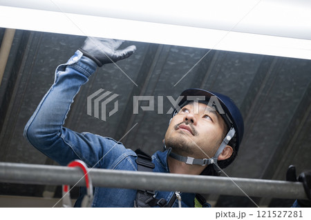 デニムを着た電気点検作業などをする電気工事士や高所作業者	 121527281