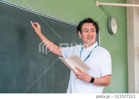 黒板の前で授業をする男性教師 121527321