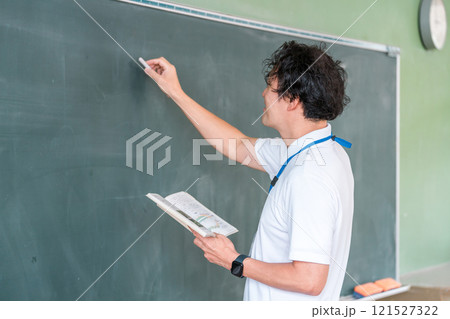 黒板の前で授業をする男性教師 黒板の前で授業をする男性教師 121527322