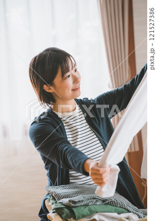 洋服をたたむ若い女性 洋服をたたむ若い女性 121527386