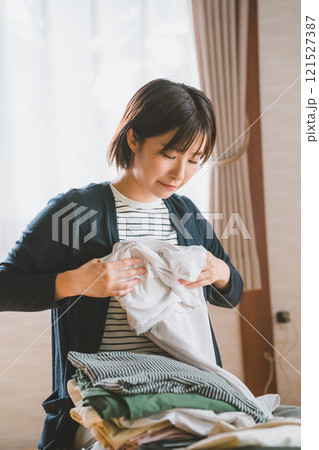 洋服をたたむ若い女性 121527387