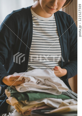 洋服をたたむ若い女性 121527389