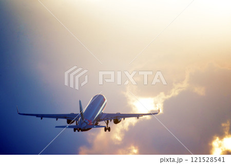 雨上がりの夕景に離陸する旅客機 121528541