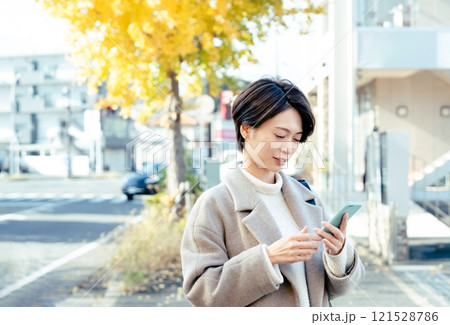 屋外でスマホを見る女性 121528786