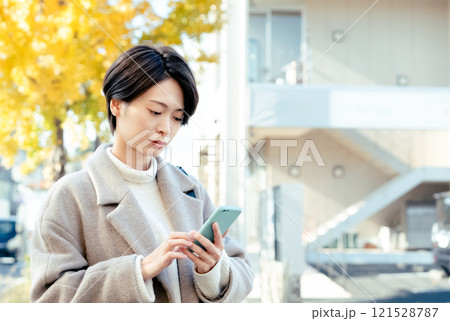 屋外でスマホを見る女性 121528787