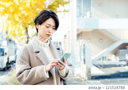 屋外でスマホを見る女性 121528788